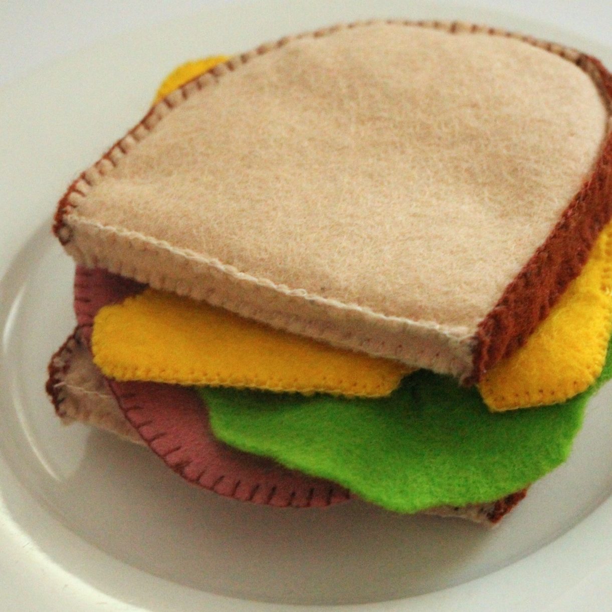 Workshops Felt-Sandwich mit Brotscheiben, Käse, Salat und einer Wurstscheibe.